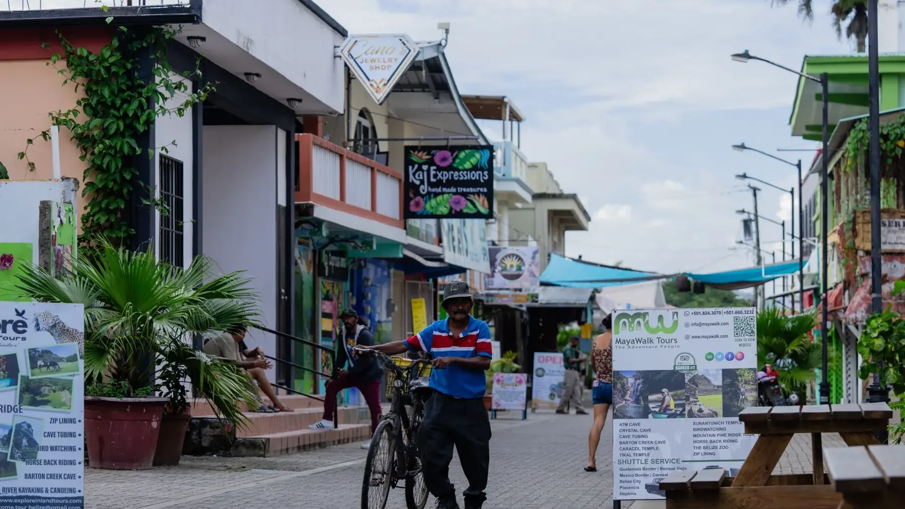 The pedestrian stretch of Burns Avenue in San Ignacio, lined with shopfronts, tables and string lights
