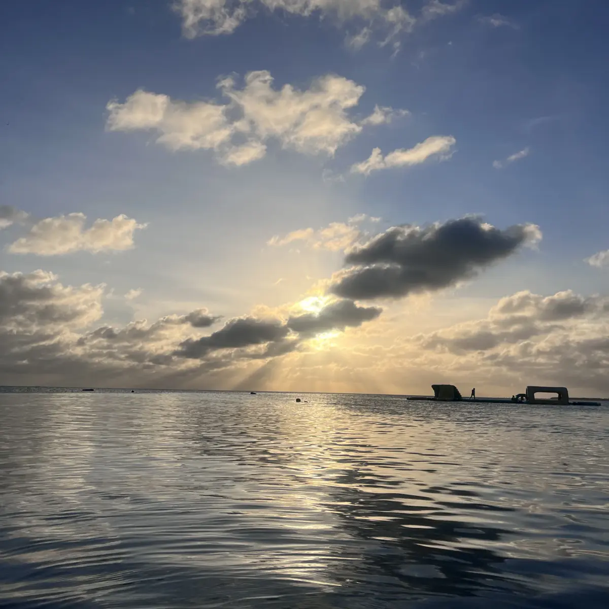 Sunset breaking through clouds over the calm Caribbean Sea near San Pedro, Ambergris Caye