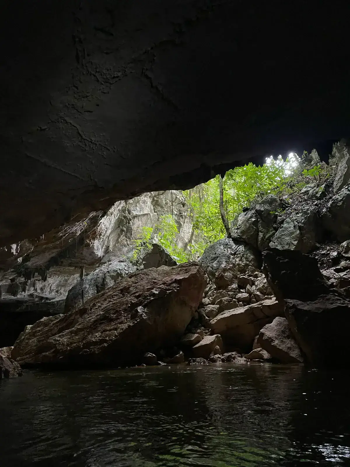 Travelers floating on inner tubes through a Belize river cave