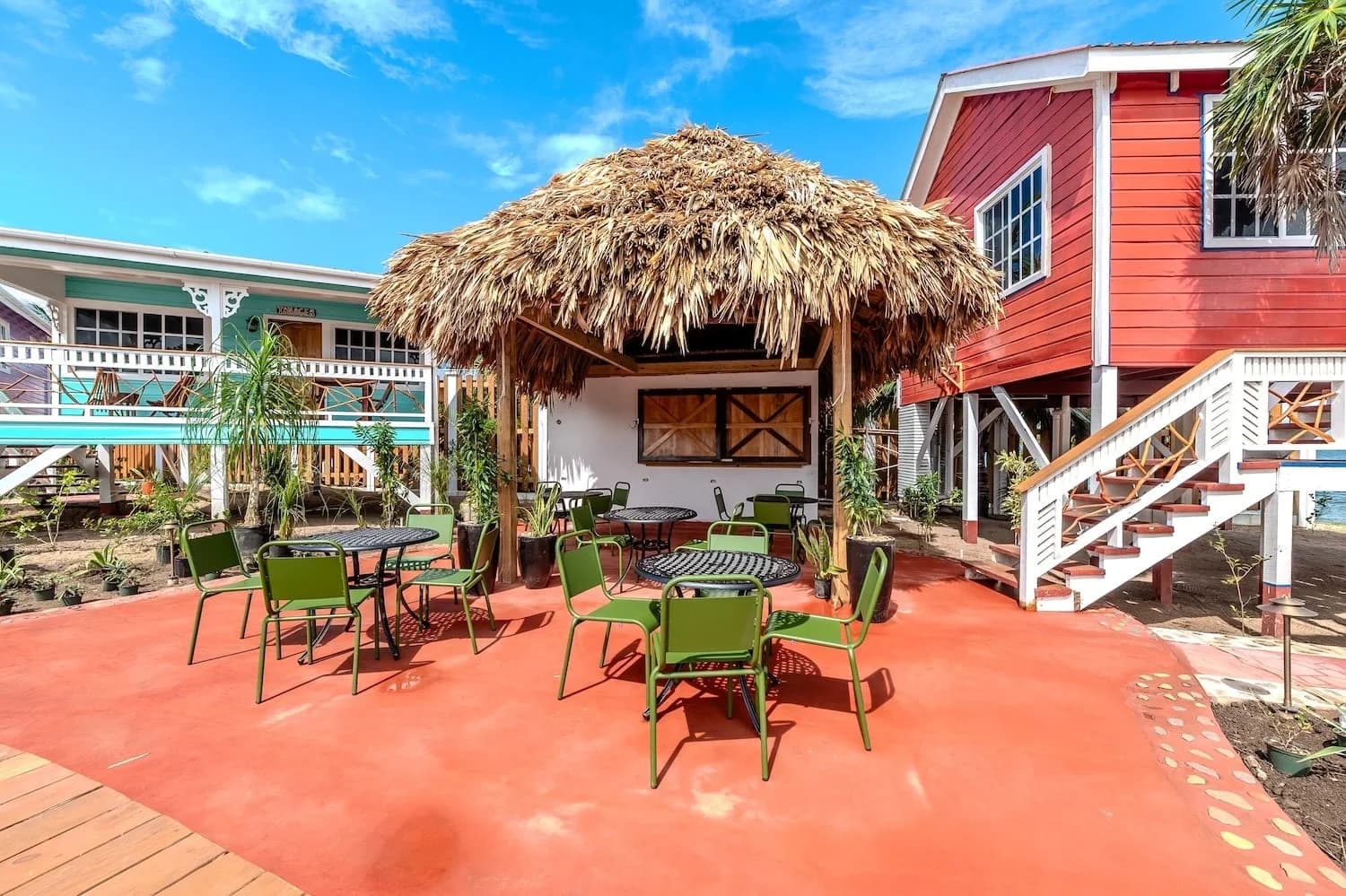 Thatched palapa lounge and dining seating beside the cabanas at Beaches and Dreams, Hopkins, Belize