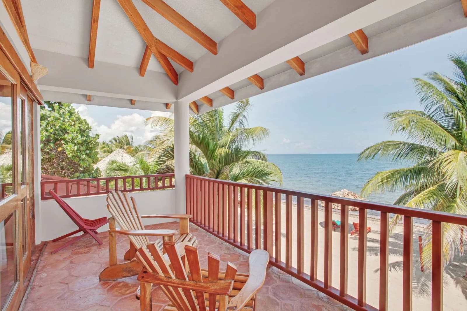 Oceanfront suite balcony with Adirondack chairs facing the Caribbean Sea at Belizean Dreams Resort