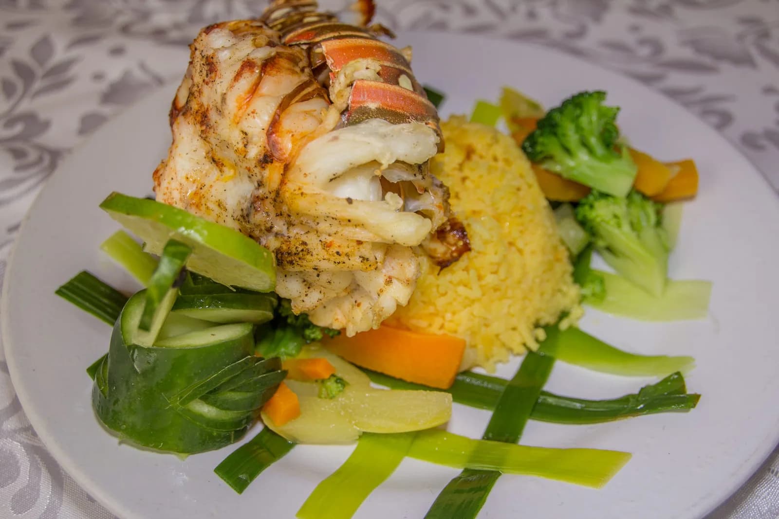 Grilled lobster tail with yellow rice and steamed vegetables served at Pan Di River Restaurant, Black Orchid Resort.