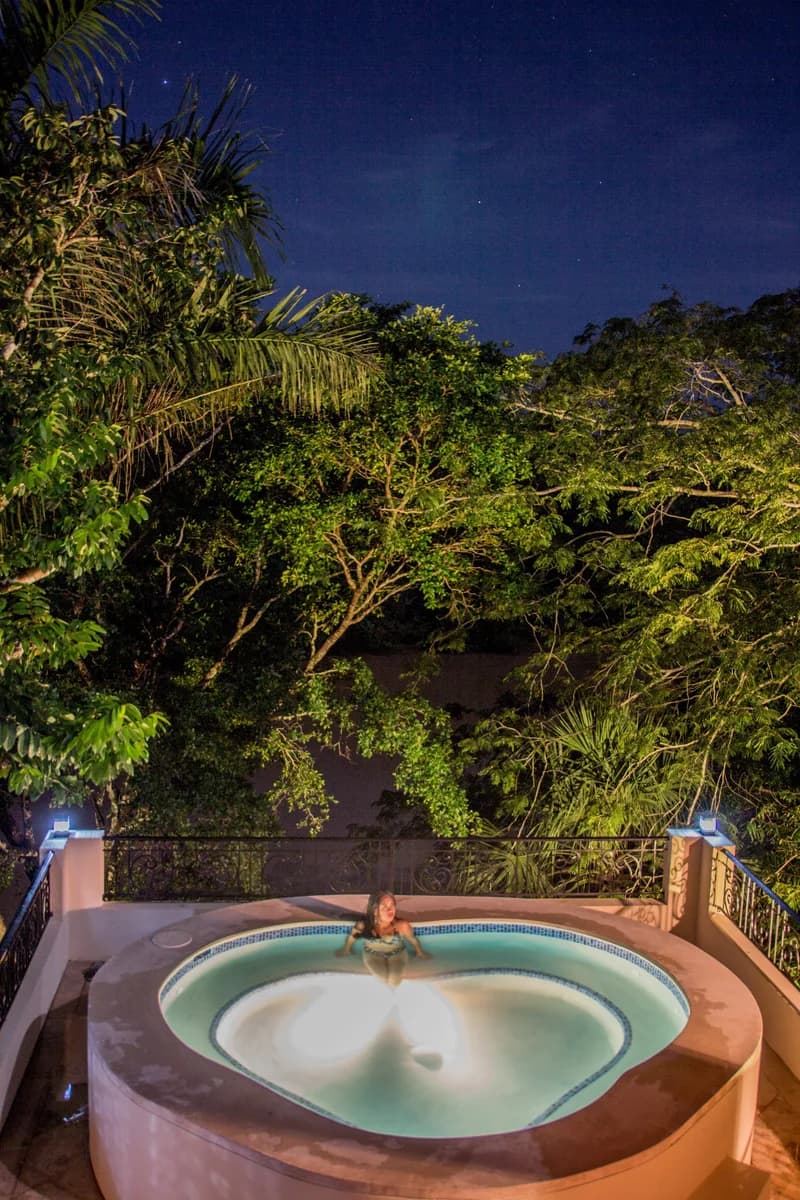 Guest relaxing in an outdoor hot tub at Black Orchid Resort under the night sky.