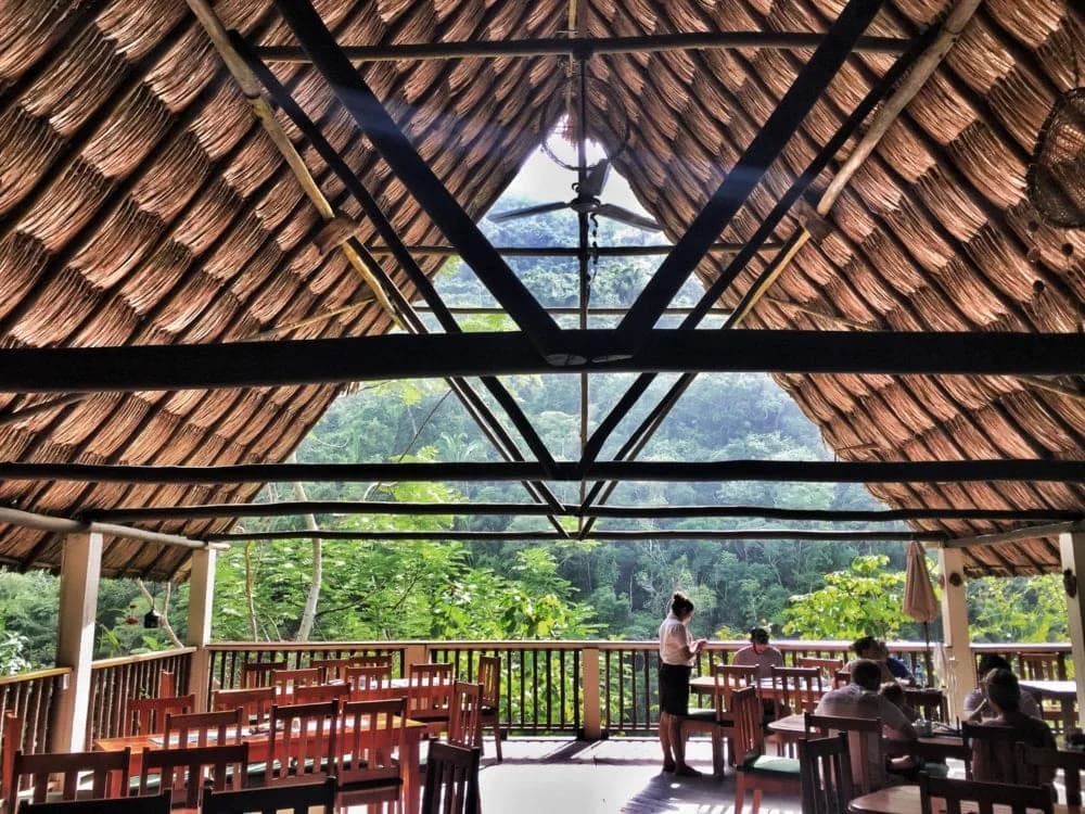 Black Rock Lodge's open-air, palapa-roofed restaurant with dining tables overlooking the jungle canyon