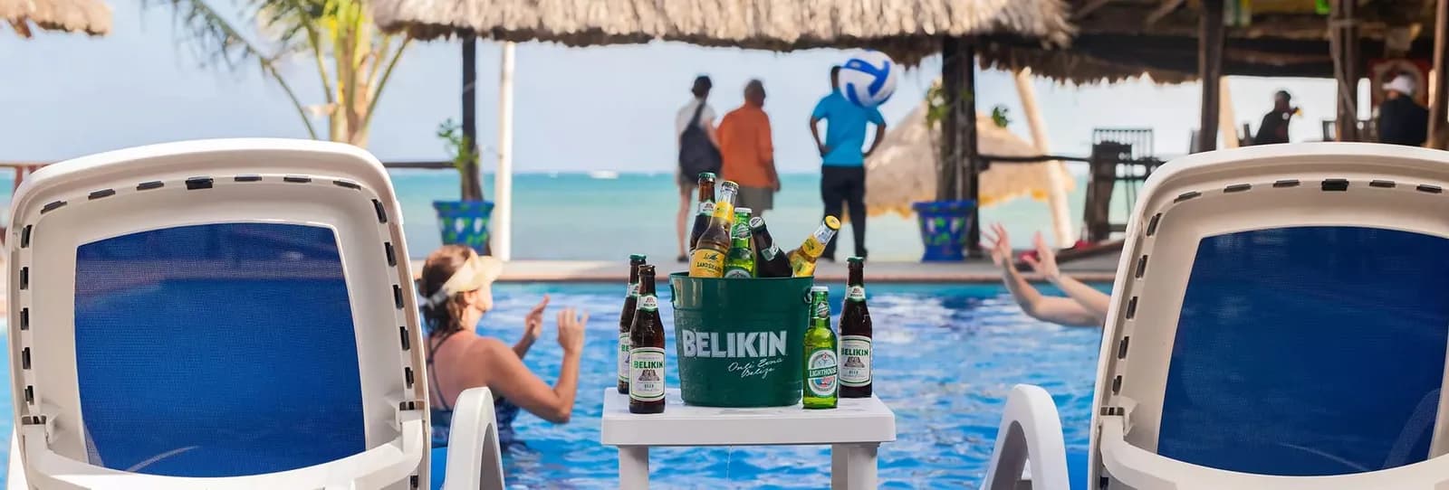 Guests relaxing poolside with a bucket of Belizean Belikin beers at the Captain Morgan's Retreat pool bar