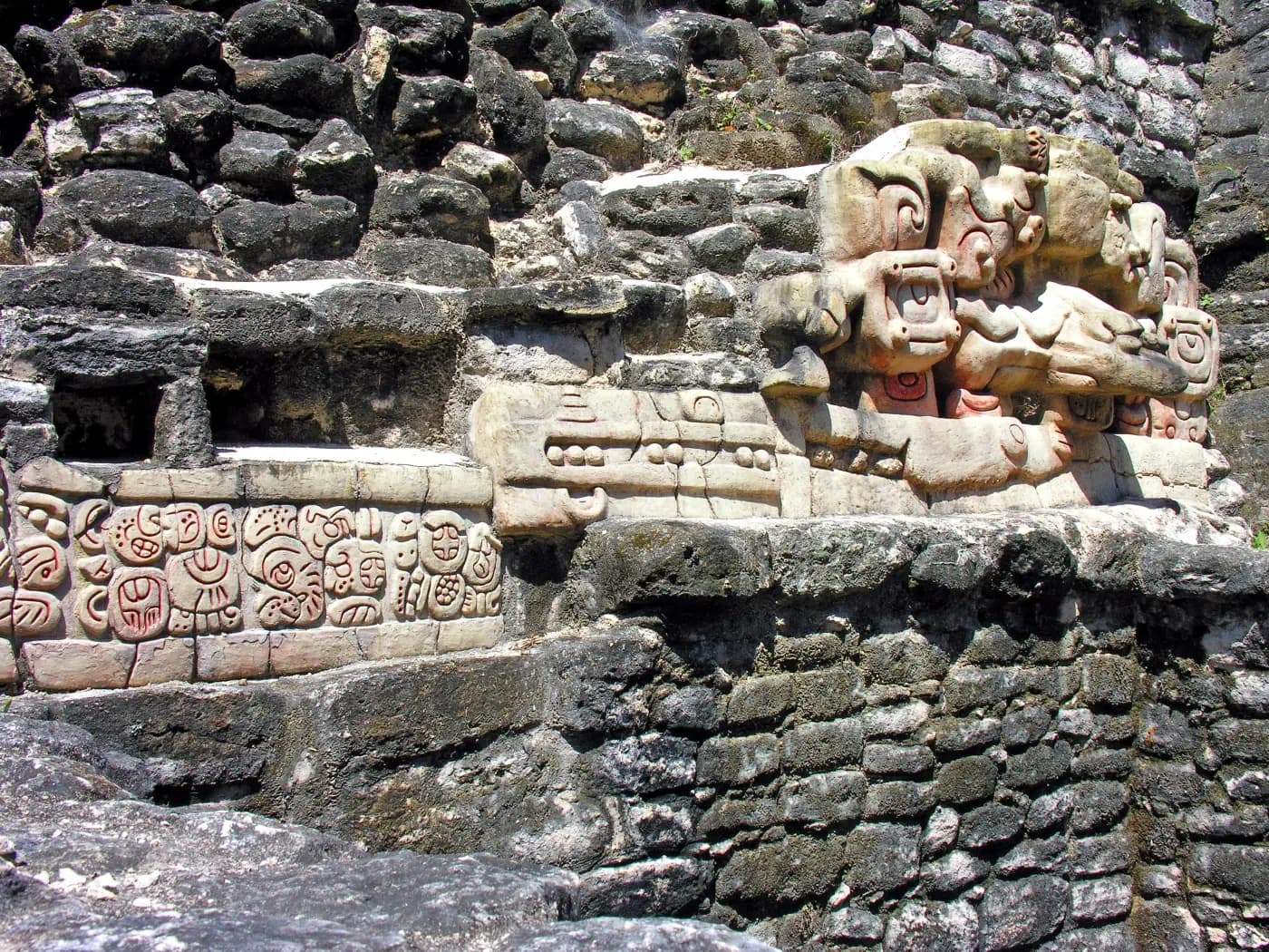Stucco mask and Maya glyph panel set into the stone architecture of Caana at Caracol.