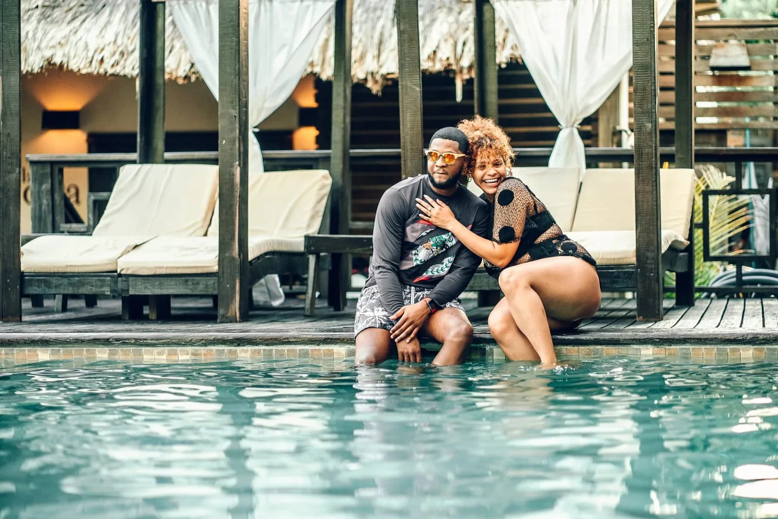 Guests at the tropical swimming pool ringed by thatched-roof cabanas at Caribbean Beach Cabanas