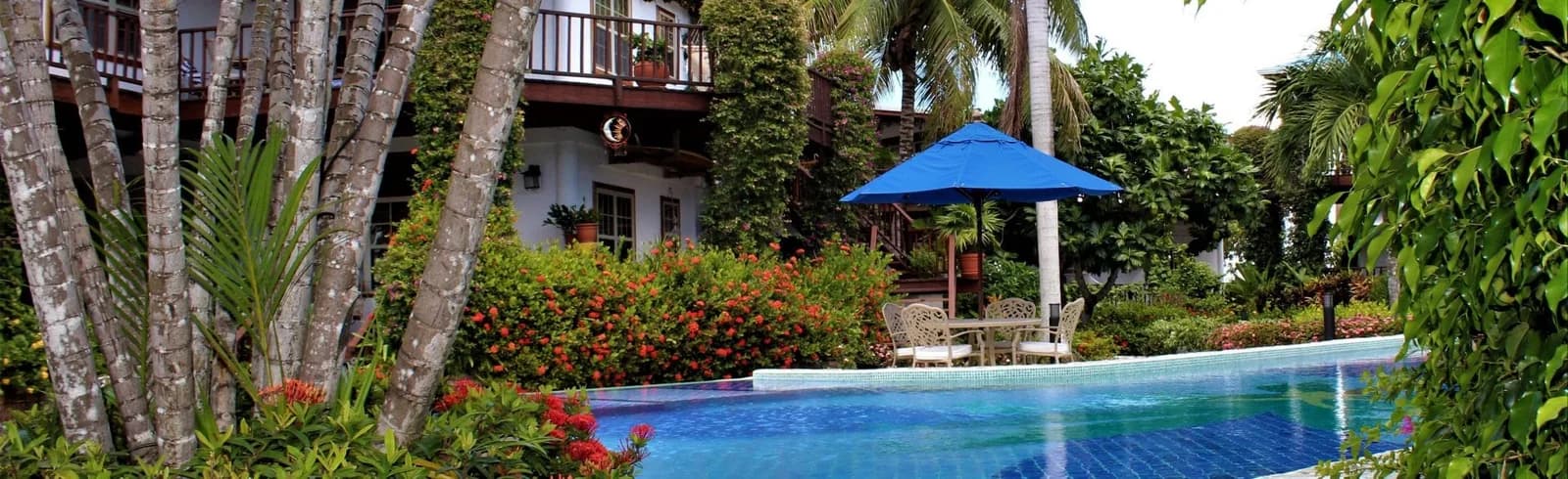 Chabil Mar Villas infinity pool framed by palm trees, villa balconies and hibiscus gardens