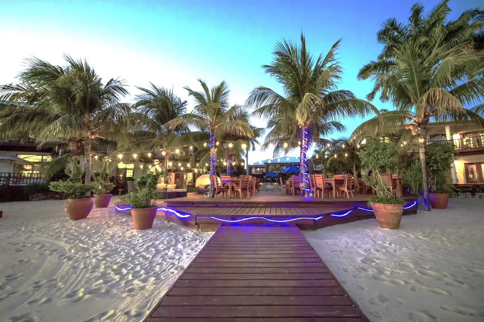 Palm-lined beachfront dining deck at Chabil Mar Villas lit up at dusk