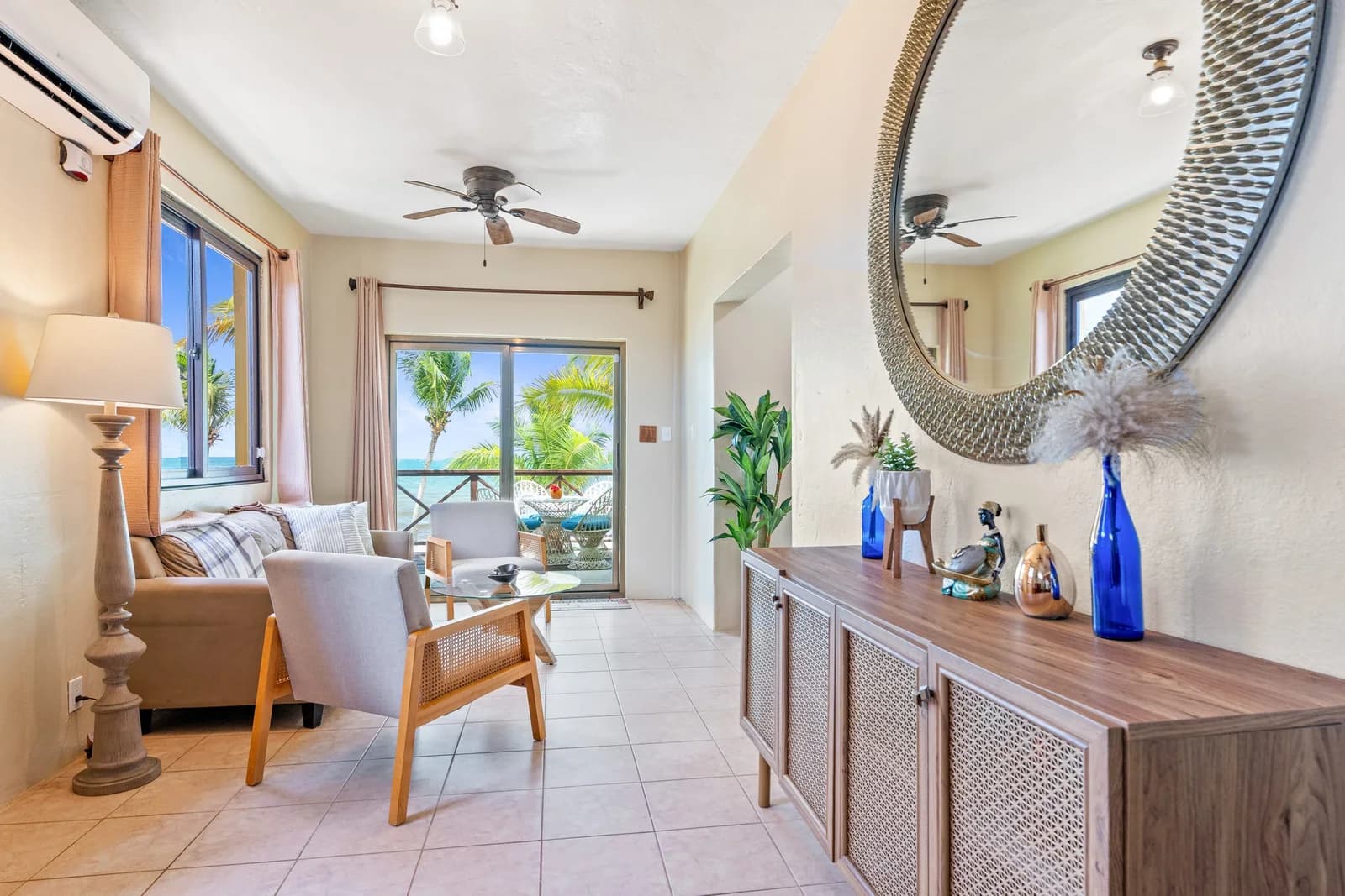 Sunrise Suite living area at Coconut Row Boutique Hotel with a private balcony overlooking the ocean and palm trees