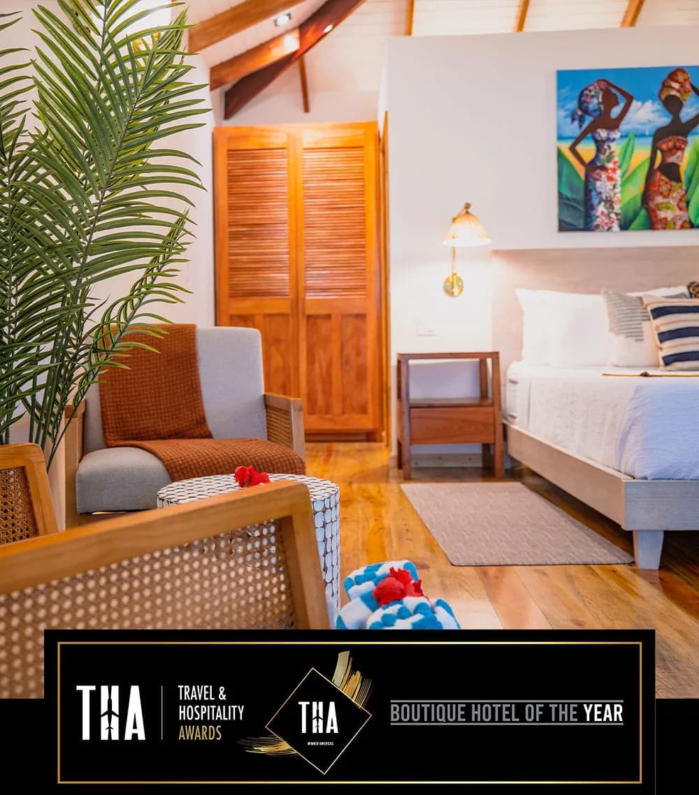Boutique guest room at Coconut Row Boutique Hotel with vaulted wood beam ceiling and cozy seating area