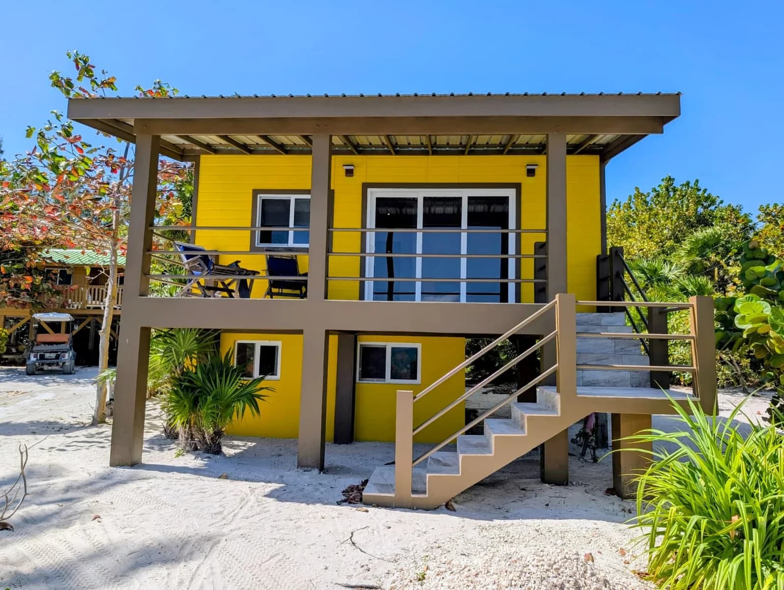 Exterior of the two-story yellow beachfront cabana (Private Beach House) at Colinda Cabanas, Caye Caulker, Belize