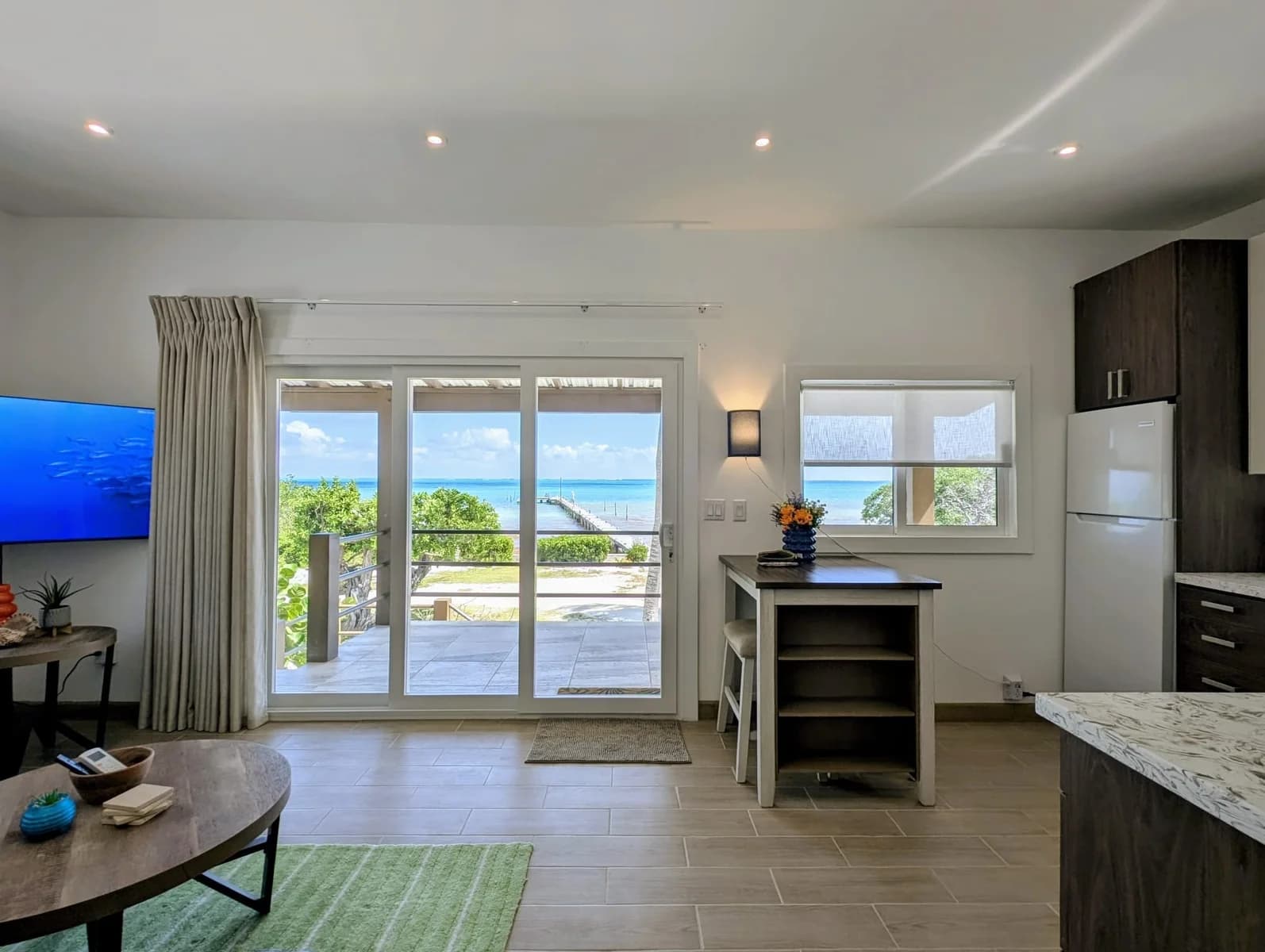 Caribbean Sea and dock view through the living room sliding doors of the Private Beach House at Colinda Cabanas