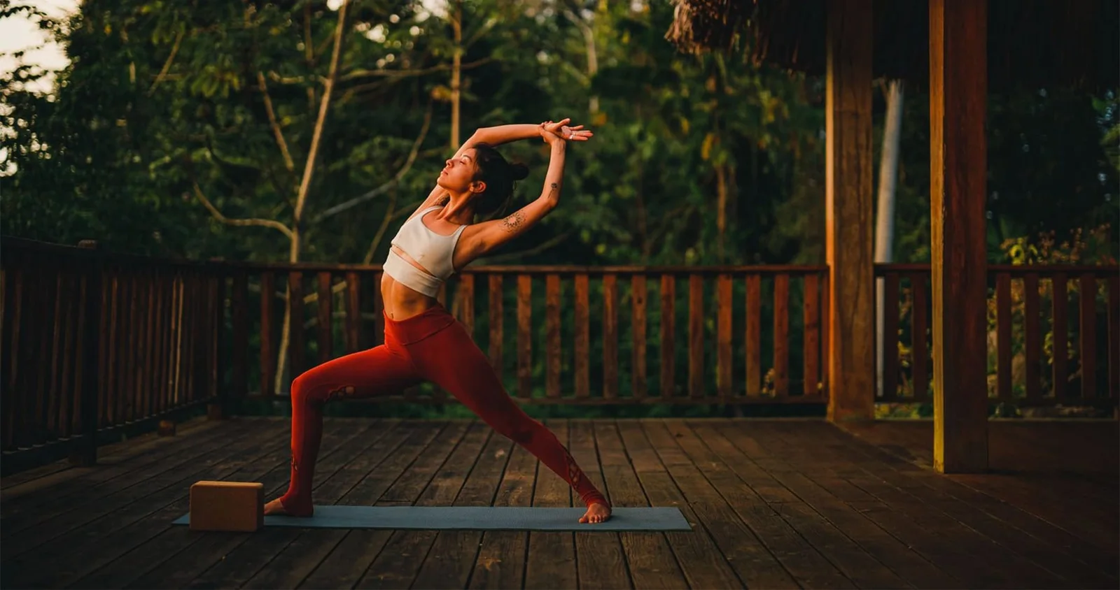 Guest practicing yoga at sunset on the treetop yoga palapa deck at Copal Tree Lodge, Belize