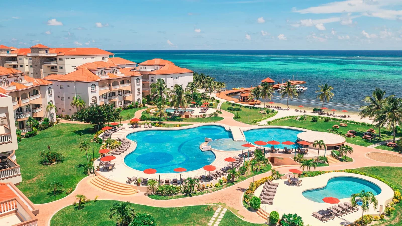Aerial view of Grand Caribe Belize's pool complex, sundeck and beachfront on Ambergris Caye