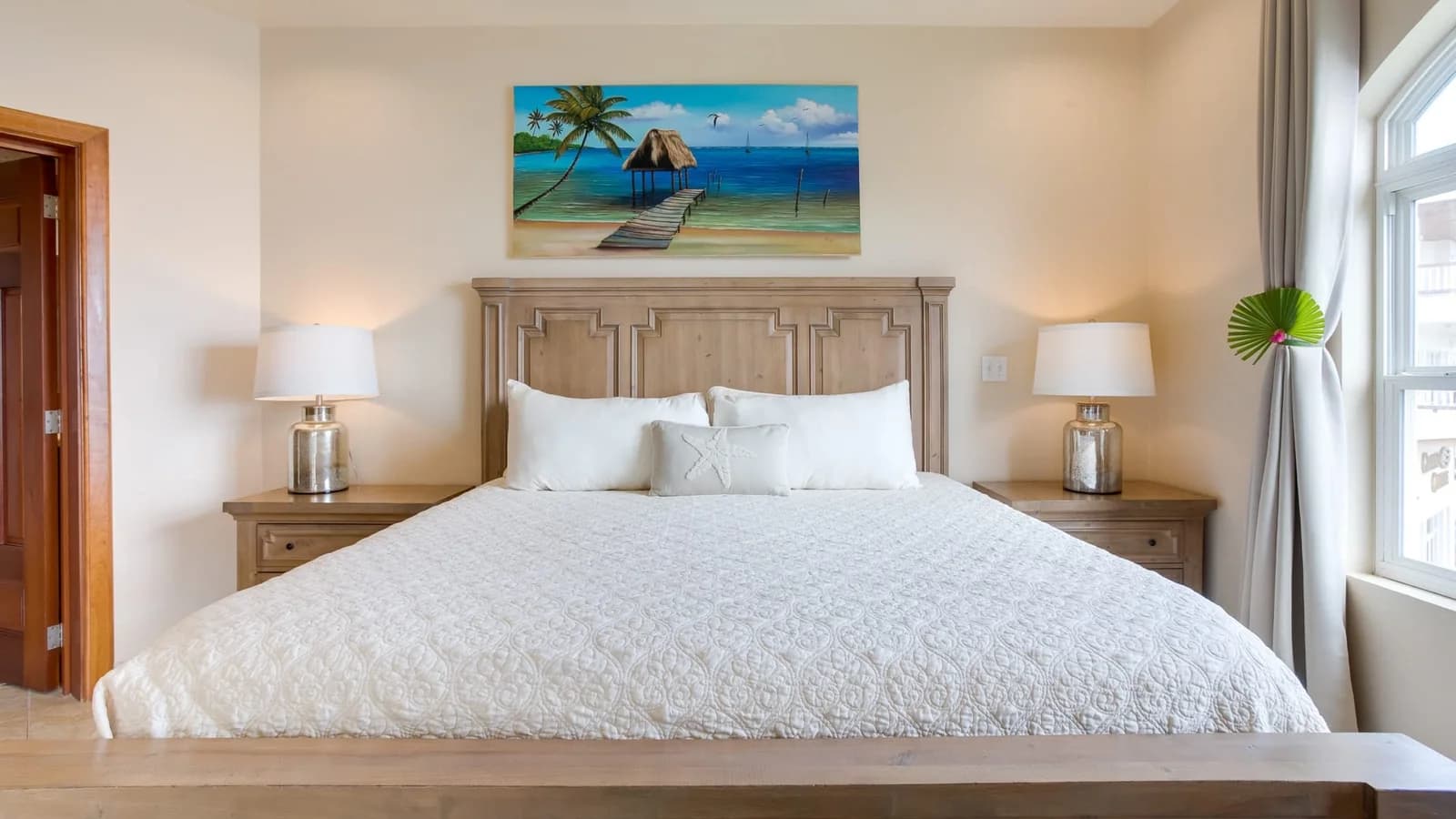Bedroom suite with a king bed and Belize-themed artwork at Grand Caribe Belize