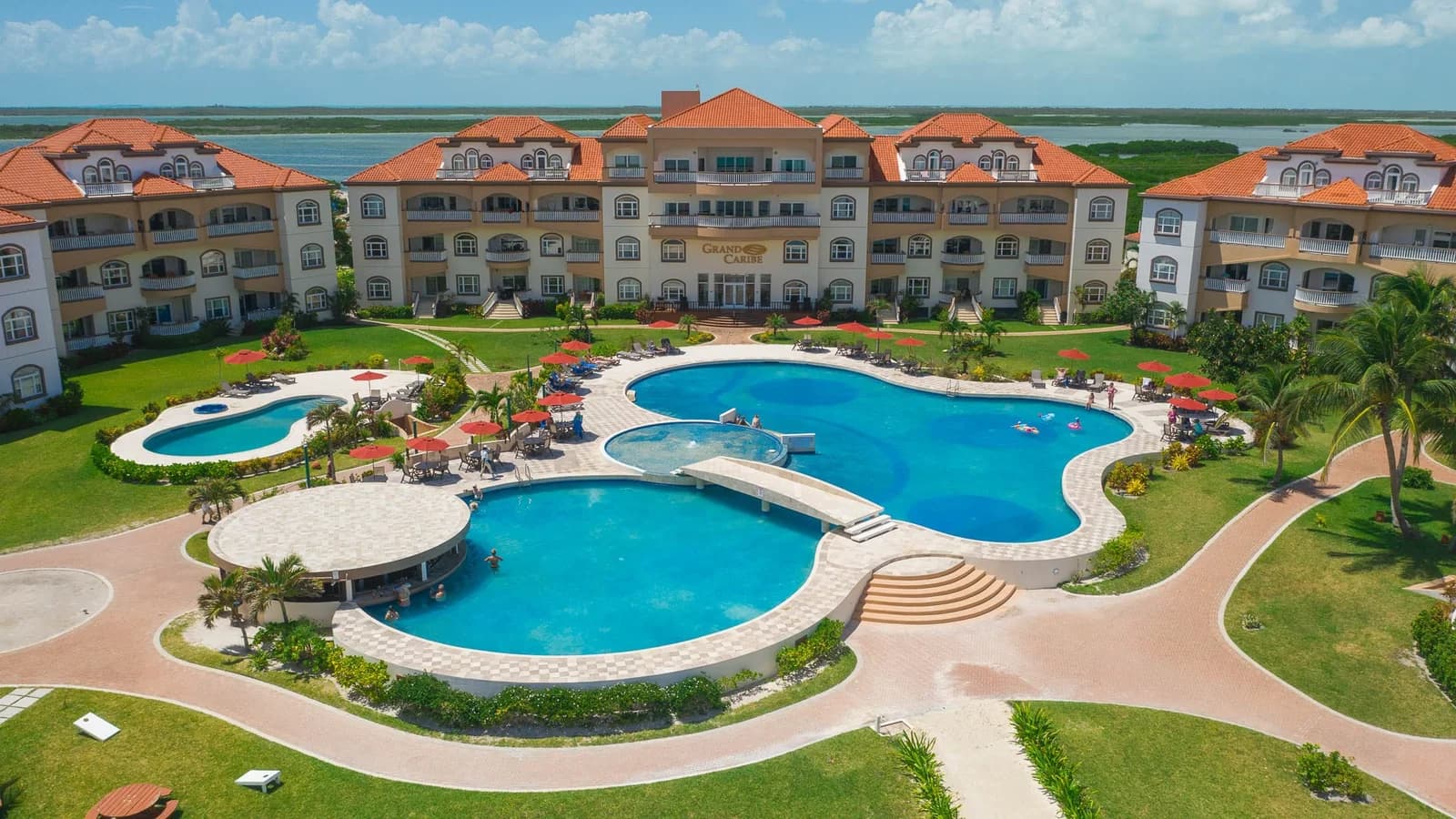 Aerial view of the Grand Caribe Belize building and pool complex with resort signage