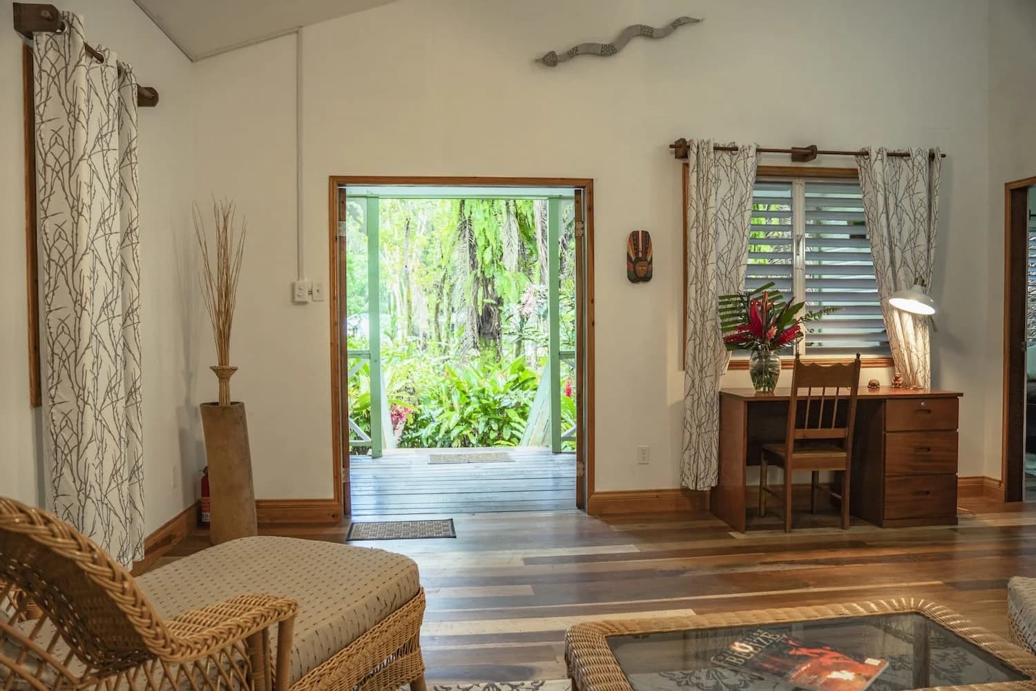 Bright living room in the Sweet Suite at Hickatee Cottages opening onto a private jungle deck