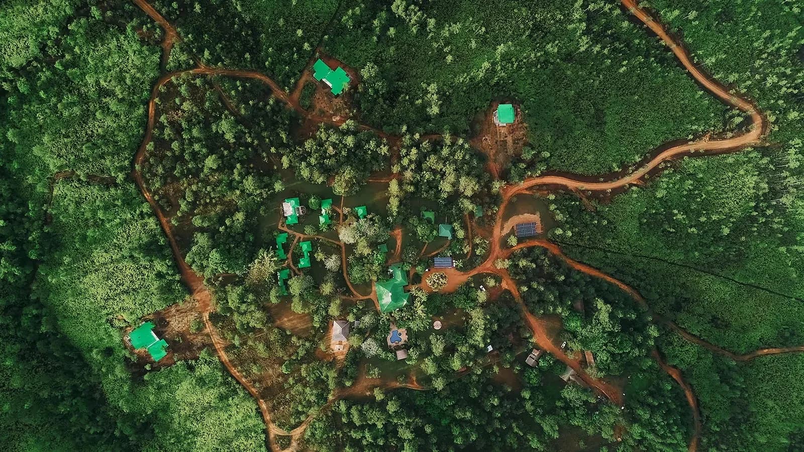 Aerial view of Hidden Valley Inn's cottages spread through the Mountain Pine Ridge forest, Belize