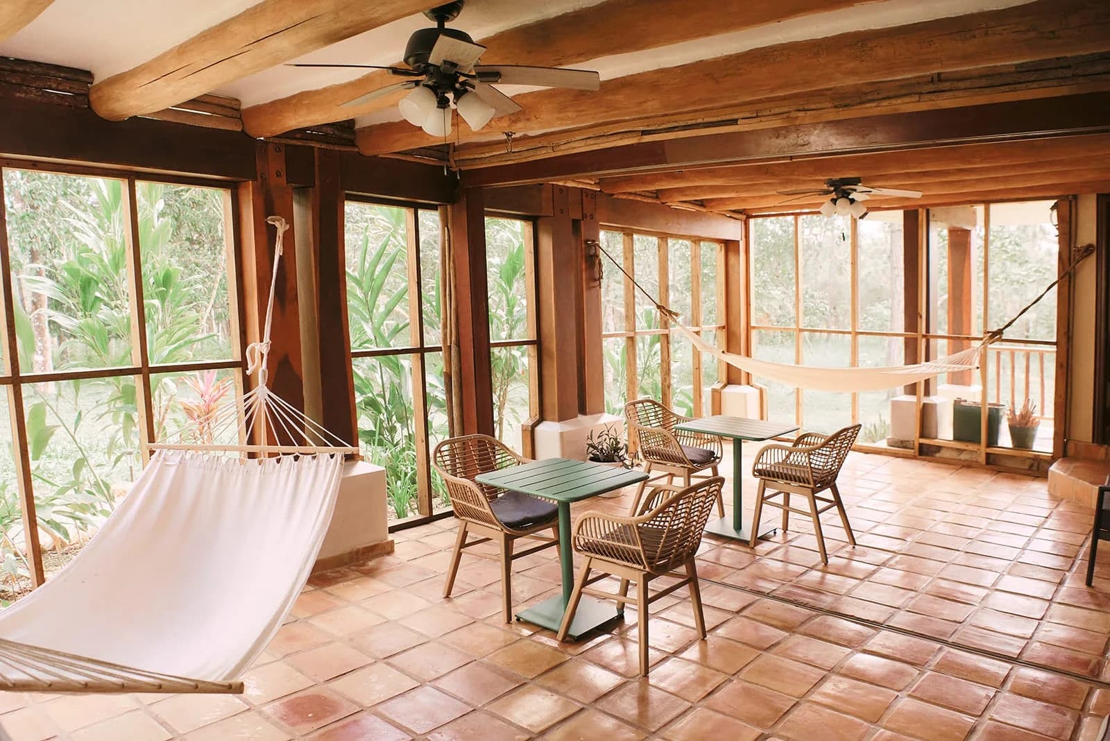 Screened lounge with hammocks and rattan seating in an Estate Cottage at Hidden Valley Inn