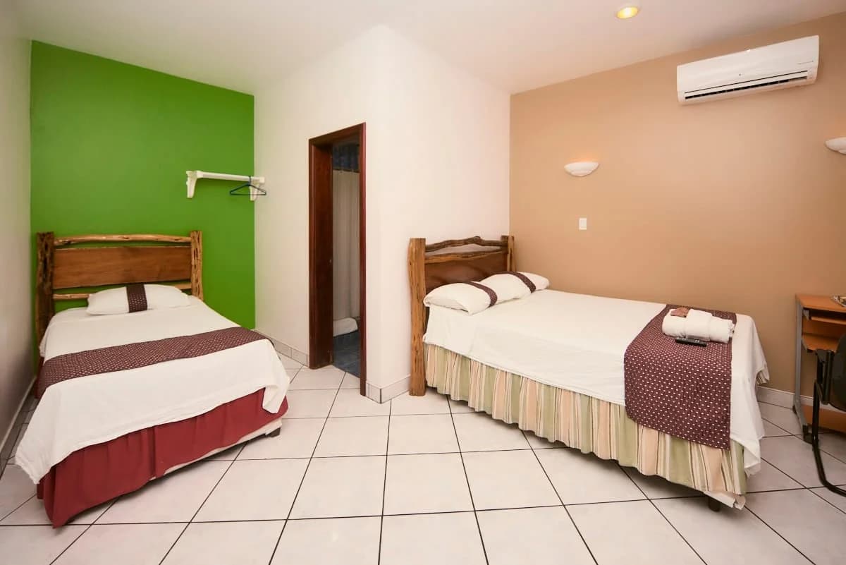 Economy twin room with two wood-framed beds at Hotel de la Fuente, Orange Walk