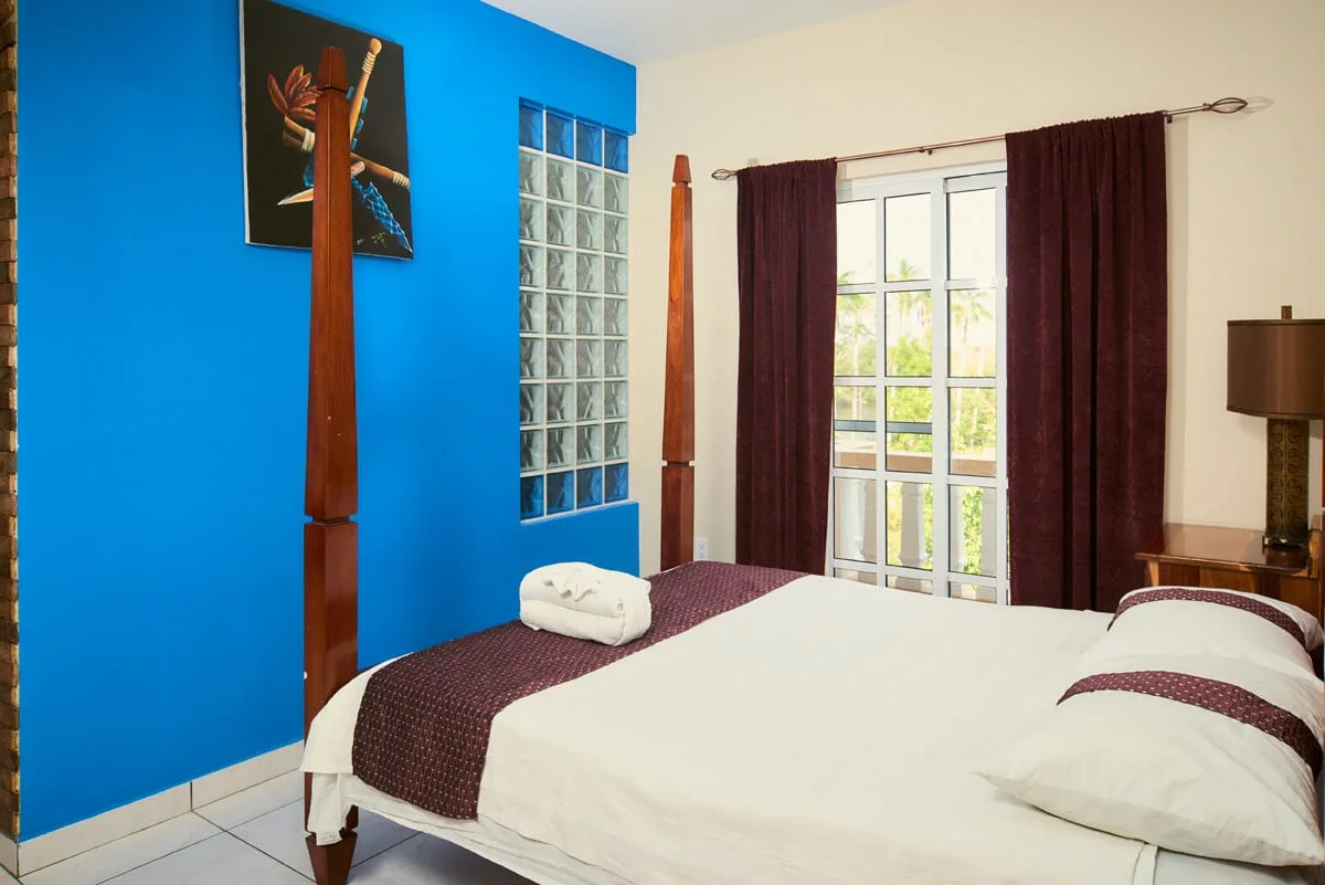 Premium room with four-poster bed and balcony doors at Hotel de la Fuente, Orange Walk