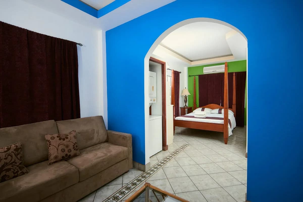 Junior suite living area and bedroom with kitchenette at Hotel de la Fuente, Orange Walk