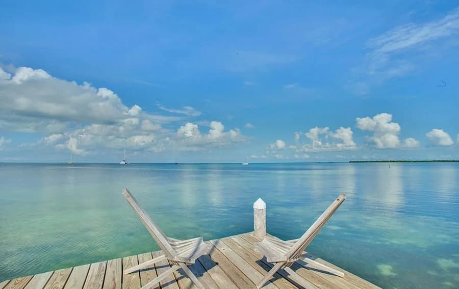 Wooden dock extending into the clear turquoise water off Iguana Reef Inn, Caye Caulker, Belize