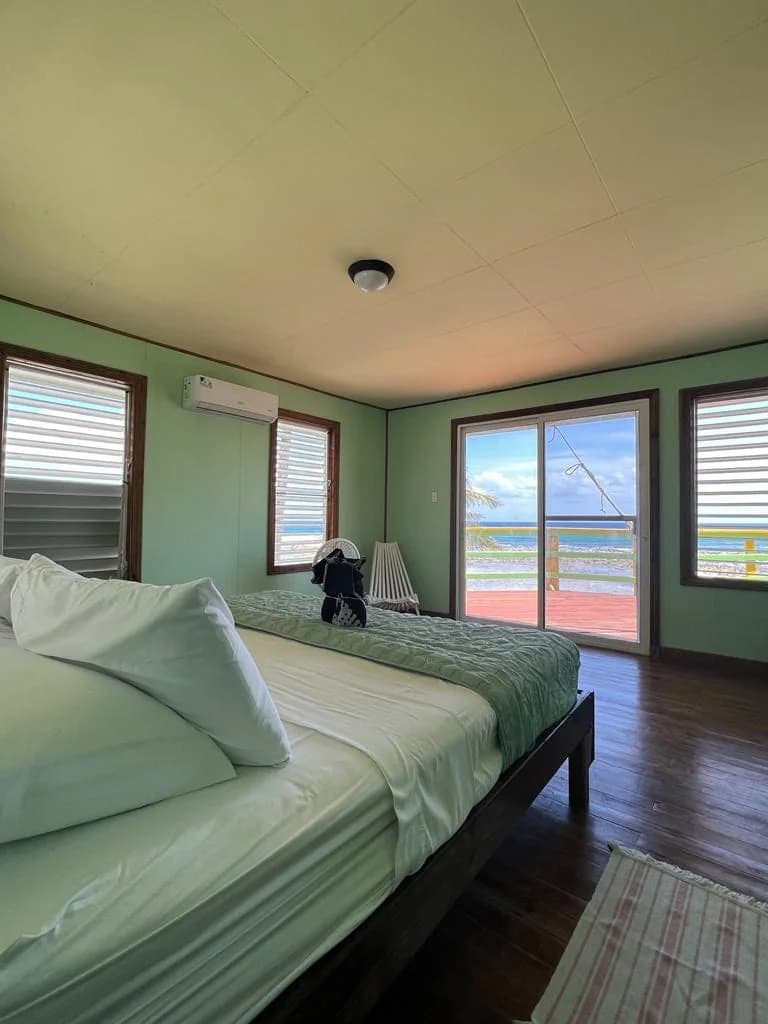 Reef house bedroom with ocean-view sliding doors at Isla Marisol Resort