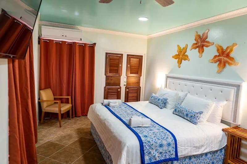 Guest room interior at Island Magic Beach Resort with king bed and starfish wall art