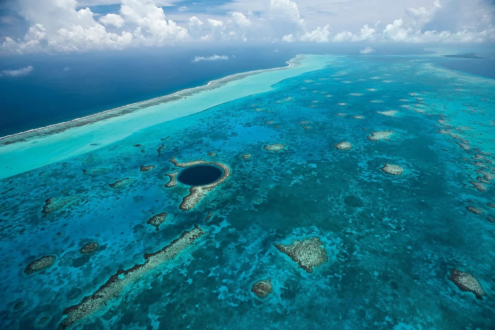 Aerial view of the Great Blue Hole within Lighthouse Reef Atoll, minutes by boat from Itza Resort on Long Caye
