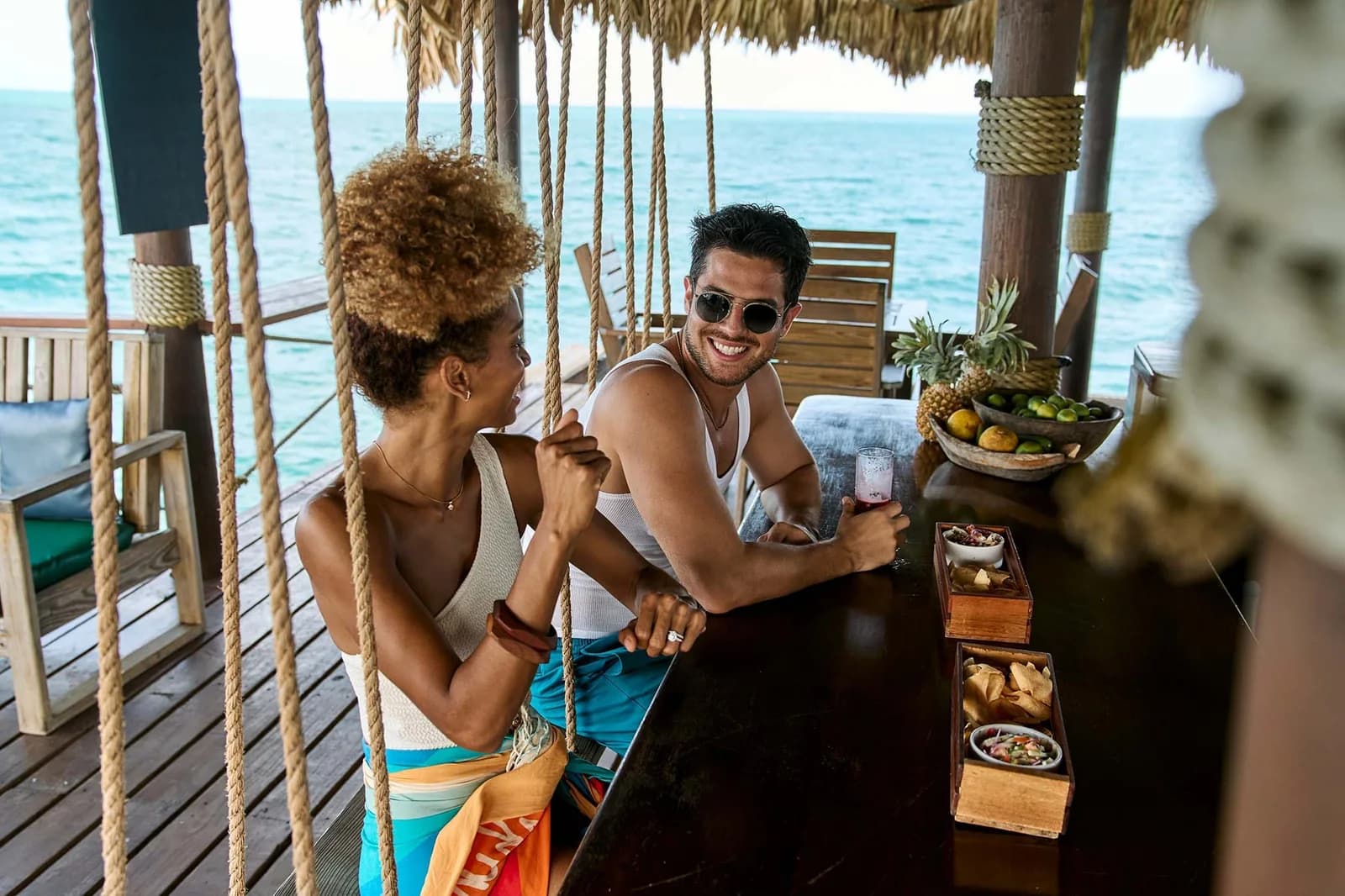 Guests enjoying drinks and ceviche at the over-water Big Dock Ceviche Bar at Jaguar Reef Lodge & Spa