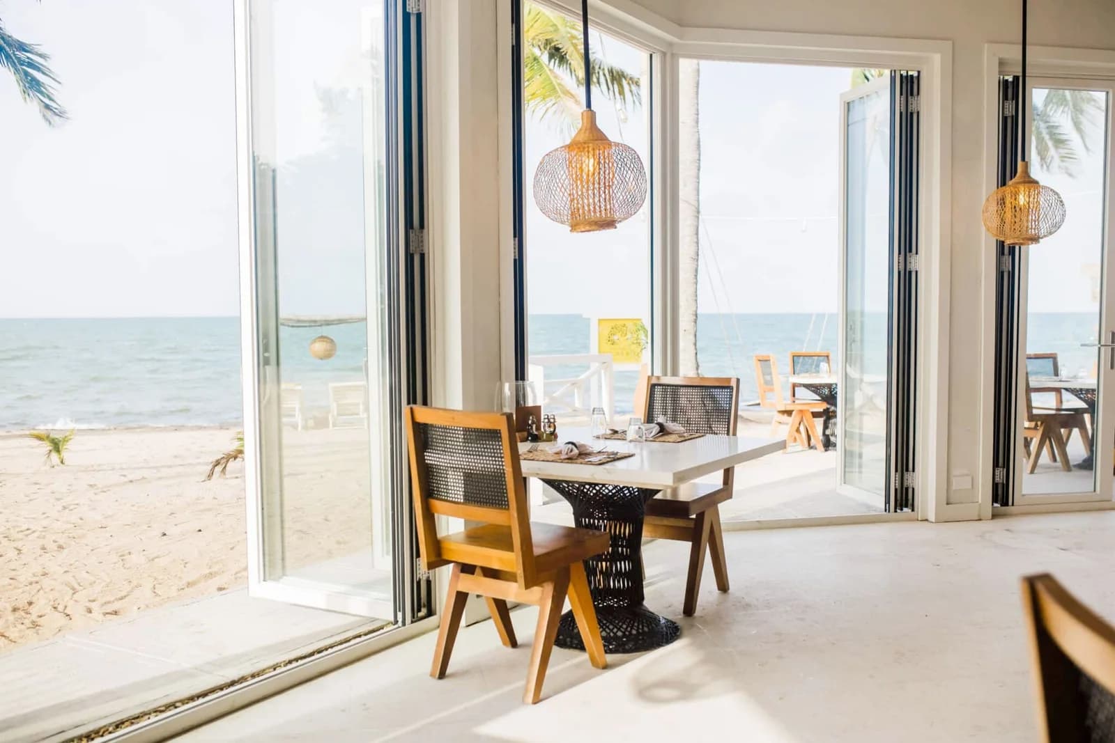 Beachfront dining tables with ocean views at The Paddle House restaurant at Jaguar Reef Lodge & Spa