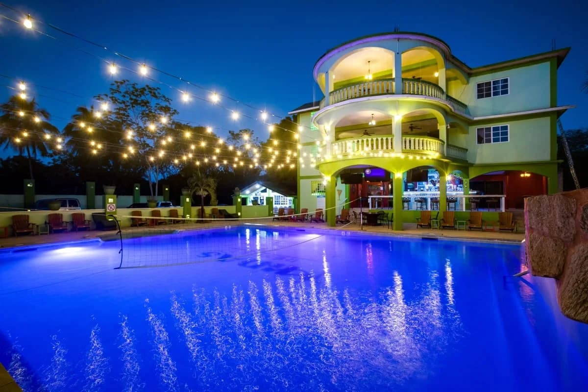 Midas Belize pool deck and poolside bar lounge area lit up in the evening