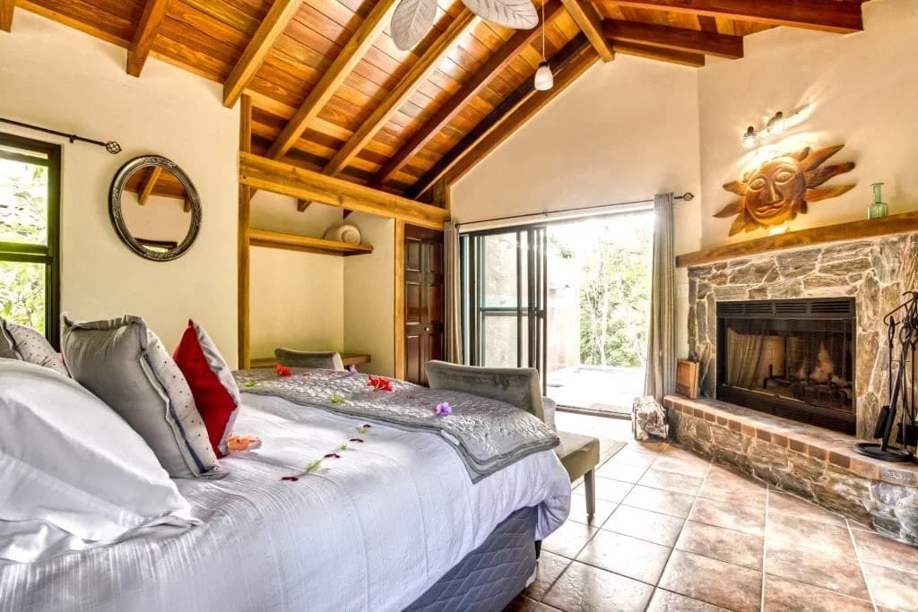 Mystic River Resort Cloud9 Suite bedroom with stone fireplace opening onto a private plunge pool