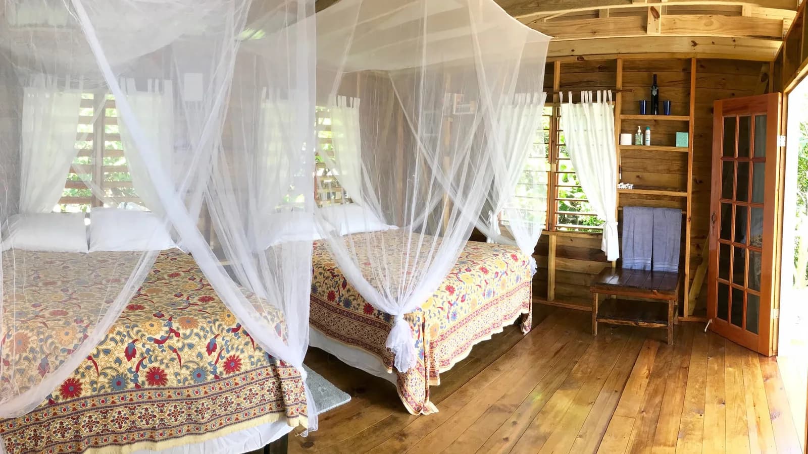 Canopy-bed guest room interior at Off The Wall Dive Center & Resort
