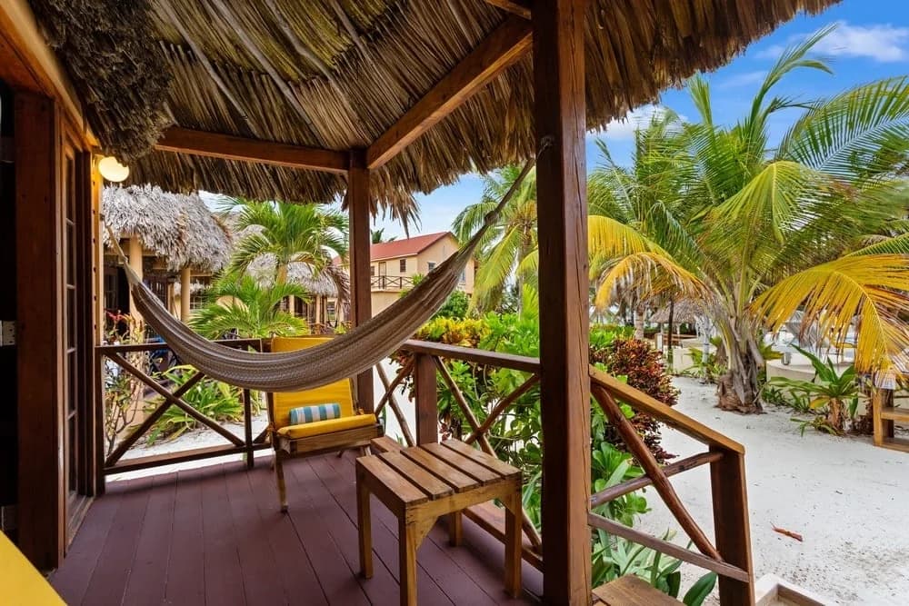 Thatched-roof Beach Cabana porch with hammock at Portofino Beach Resort, Ambergris Caye