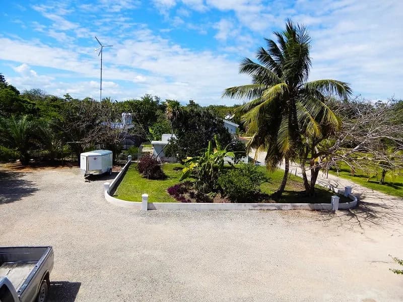 Grounds of Serenity Sands Bed & Breakfast showing the wind turbine and palm trees used for off grid power