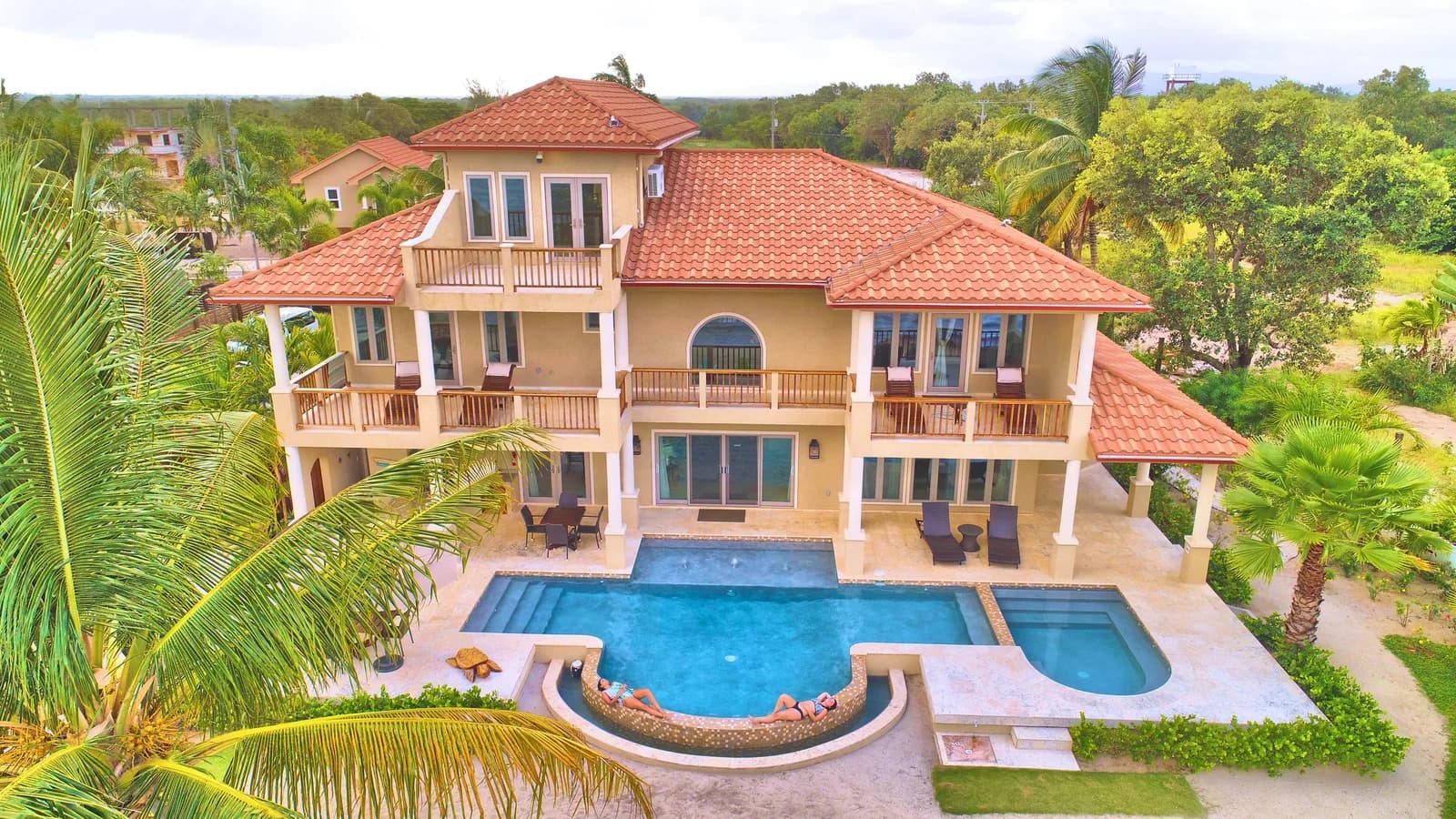 Exterior of a two-story Manatee Villa at Sirenian Bay with private plunge pool and Spanish tile roof, Placencia, Belize