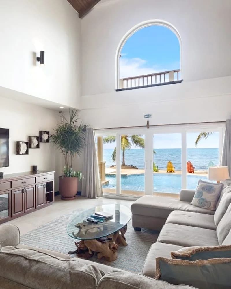 Living room interior of the Manatee Villa at Sirenian Bay with sofa seating and a direct ocean view, Placencia, Belize