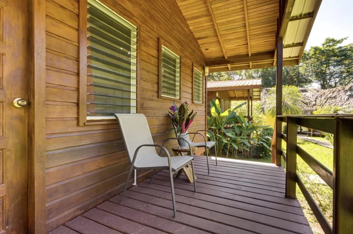 Covered veranda with seating outside a hardwood cabana at Tanager Rainforest Lodge