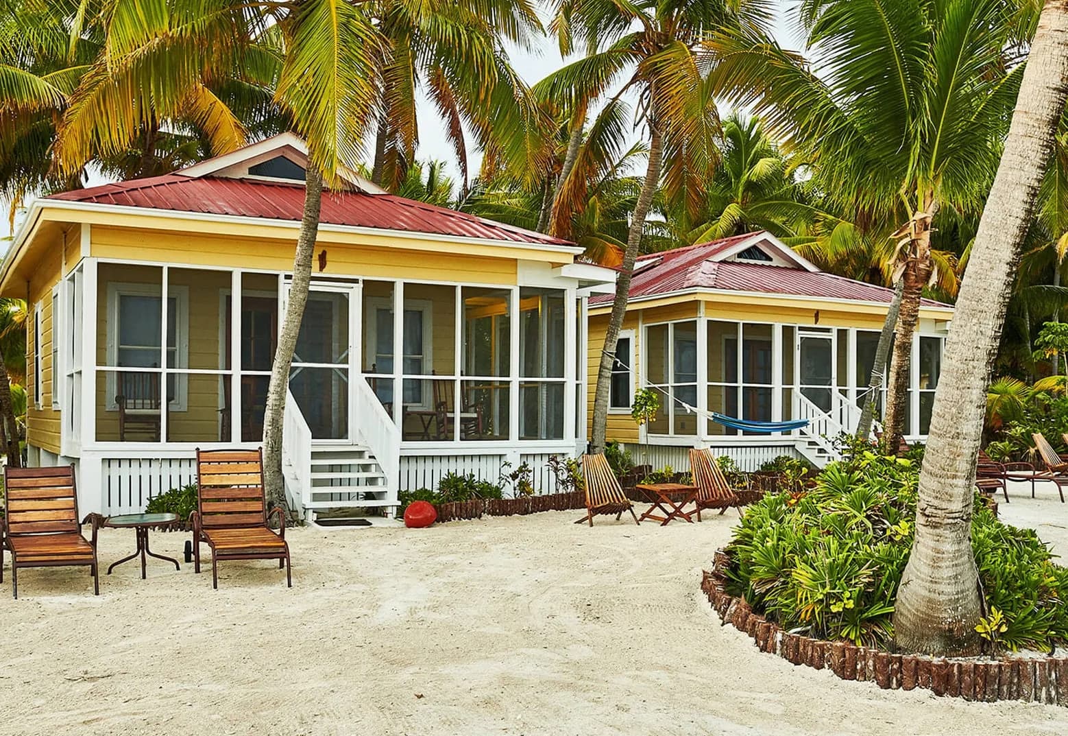 Private Villa cottages with red tin roofs on the beach at Turneffe Island Resort