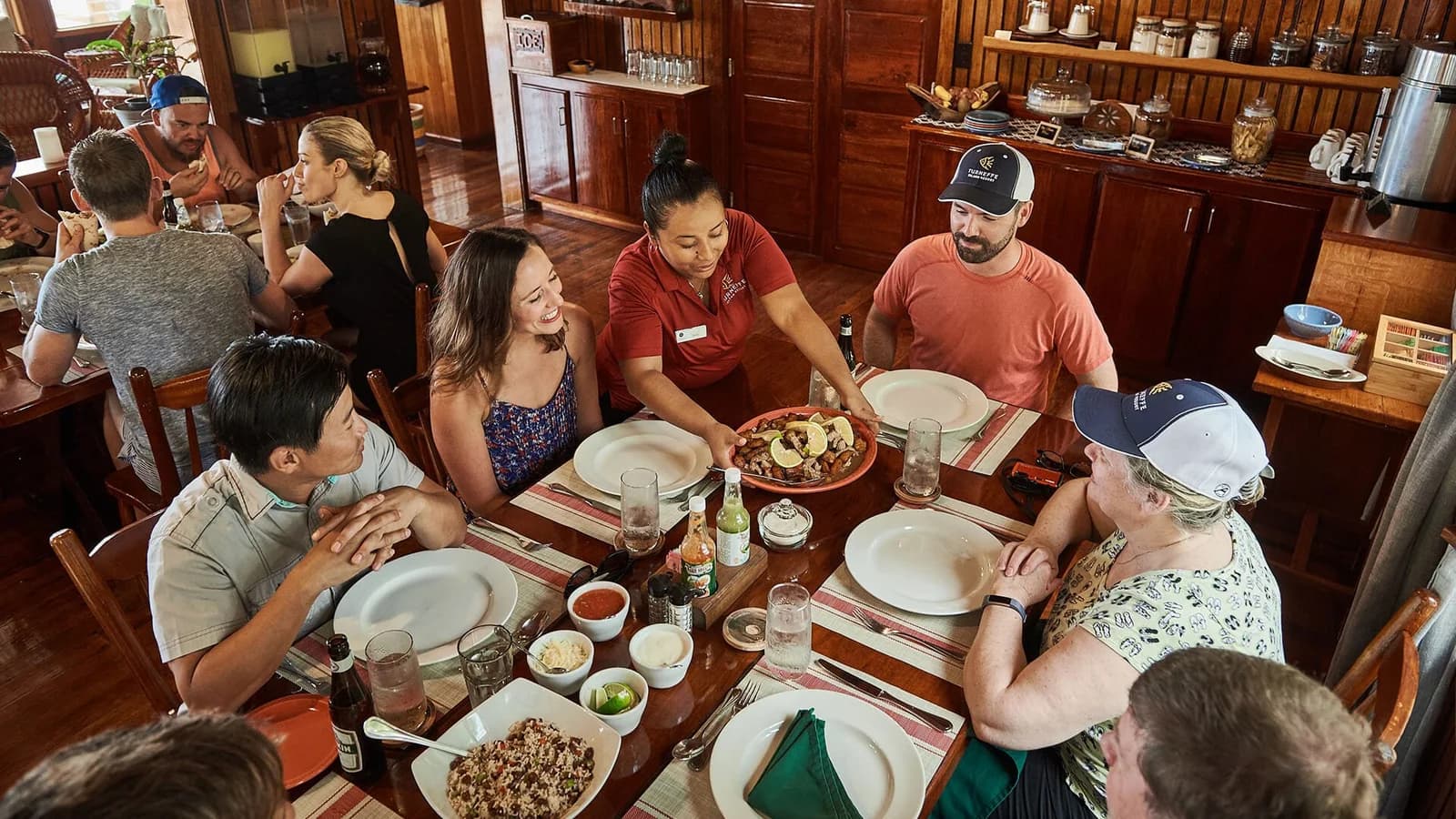 Guests enjoying family style Belizean dining at Turneffe Island Resort