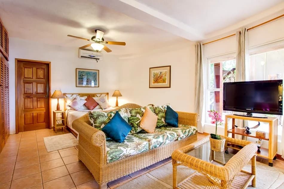Living area of a Garden View Studio Suite at Xanadu Island Resort with rattan furniture and a flat screen television