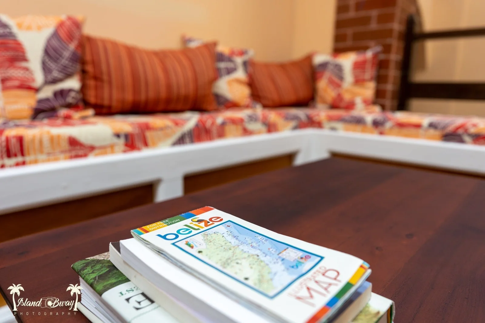 Cozy lounge nook with patterned cushions and travel guidebooks at Yellow Belly Backpackers hostel, San Ignacio, Belize