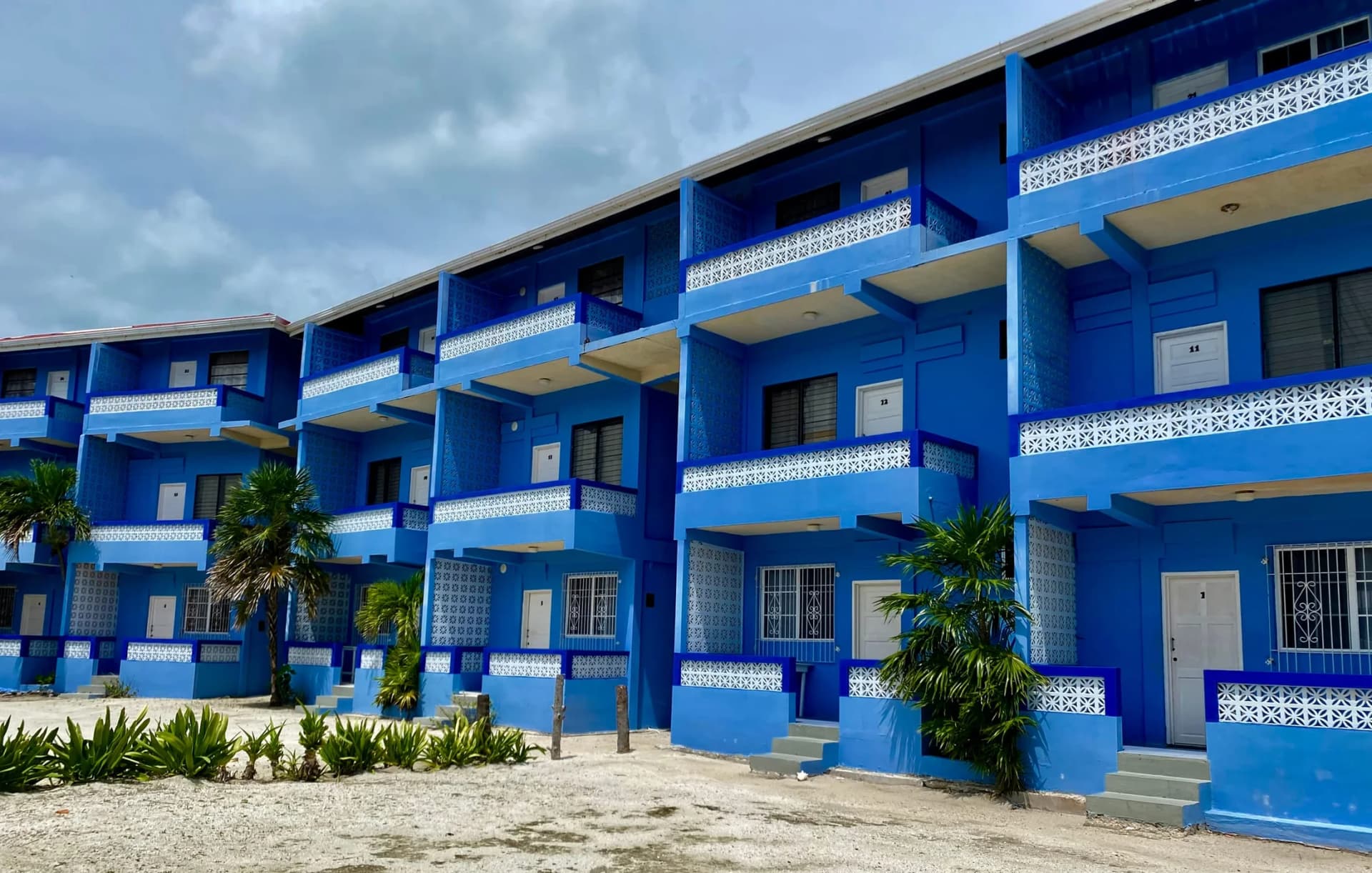 Anchorage Beach Resort's three-story cobalt blue guest building with private balconies on Caye Caulker
