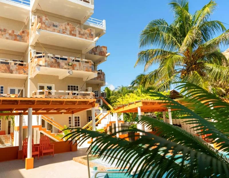 Island Magic Beach Resort's multi-story guest building with stone-accented balconies overlooking the pool and hot tub deck