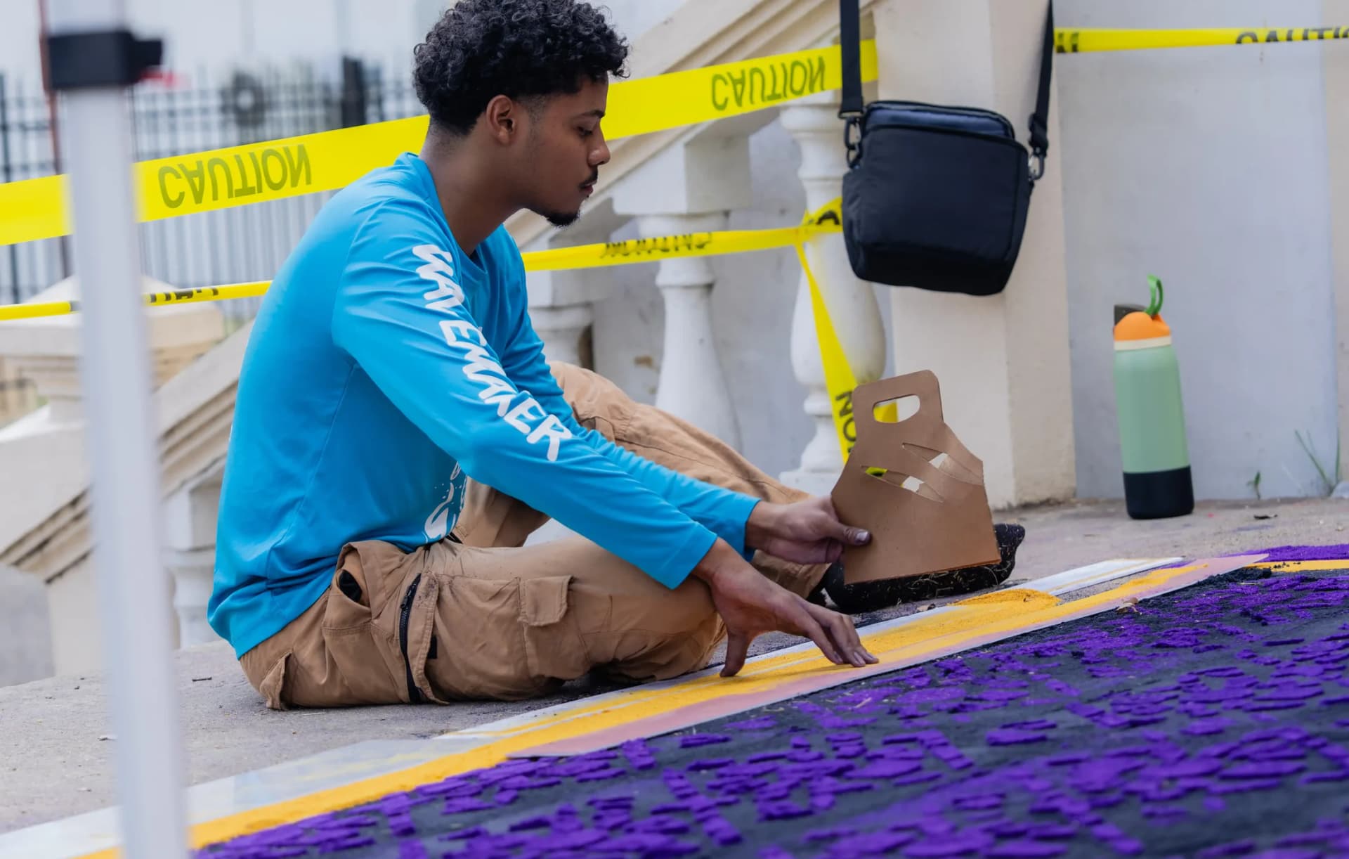 Volunteers laying a vibrant dyed sawdust alfombra carpet on the main street of Benque Viejo del Carmen, Belize, in the early morning hours of Good Friday.